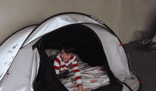 enfant souriant dans une tente