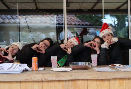 Enfants avec bonnets de Noël heureuses lors de la découverte du calendrier de l'avent